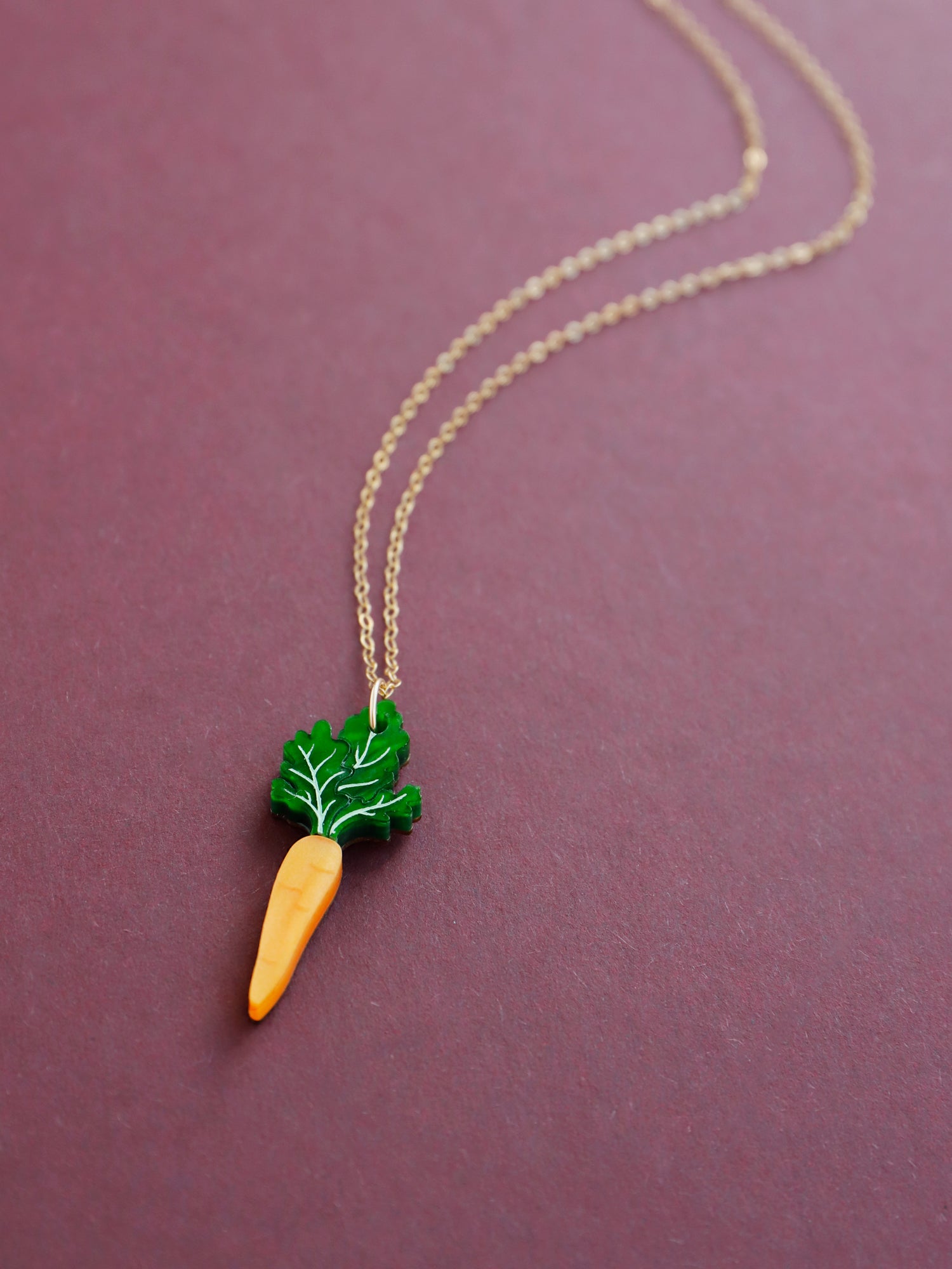 Green and orange hand-inked acrylic mini carrot pendant with optional gold-filled chain. Handmade in London by Wolf & Moon.