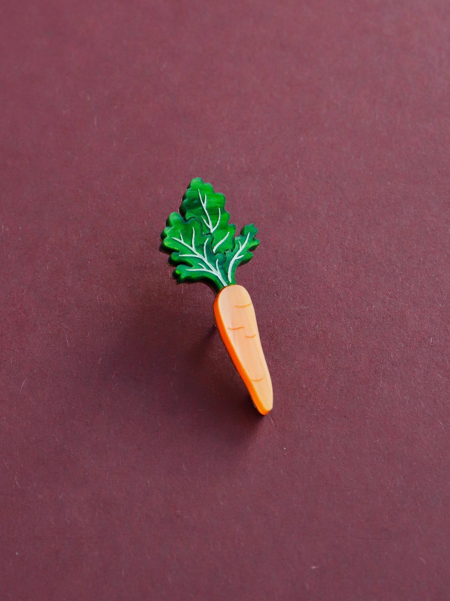 Green and orange hand-inked acrylic mini carrot pin. Handmade in London by Wolf & Moon.