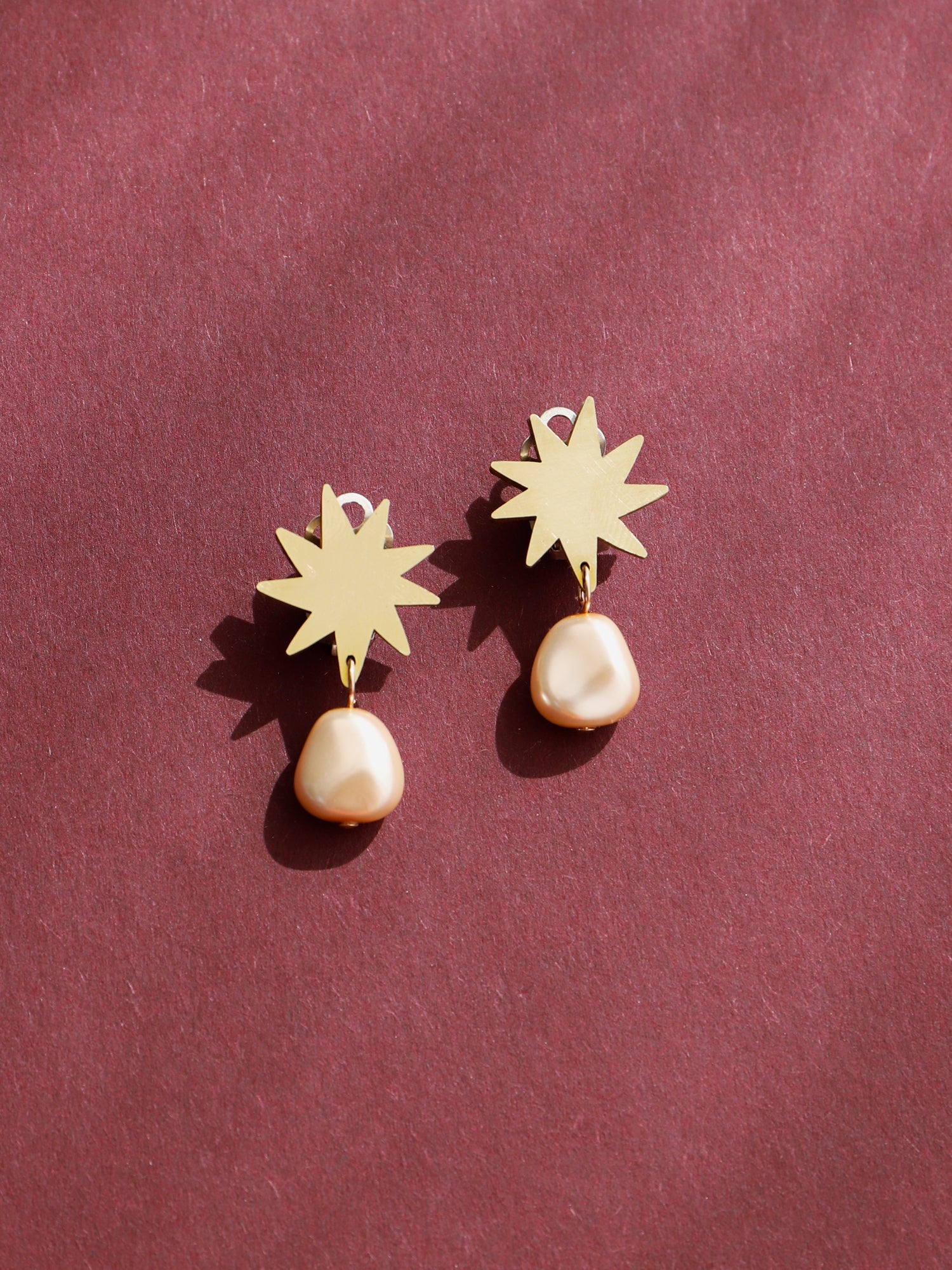 Elegant drop clip-on studs, inspired by Matisse's cutout-style stars. Made in brass with our signature wood base, Czech glass baroque pearls and sterling silver earring clip-on clasps. Handmade in the UK by Wolf & Moon.