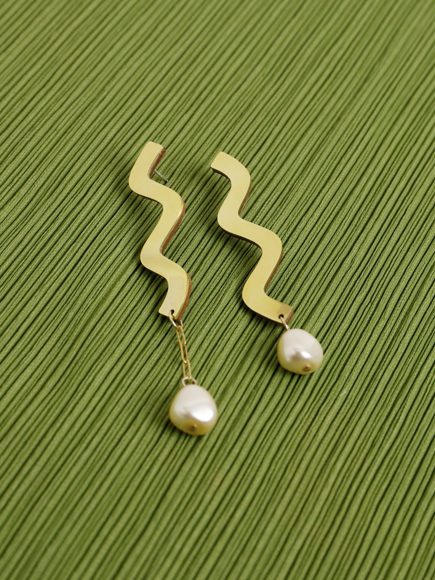 Martha Earrings in Brass. Wavy asymmetric statement earrings made in brass with our signature wood base, Czech glass baroque pearls, 14k gold-filled chain and sterling silver earring posts. Made in the UK by Wolf & Moon.
