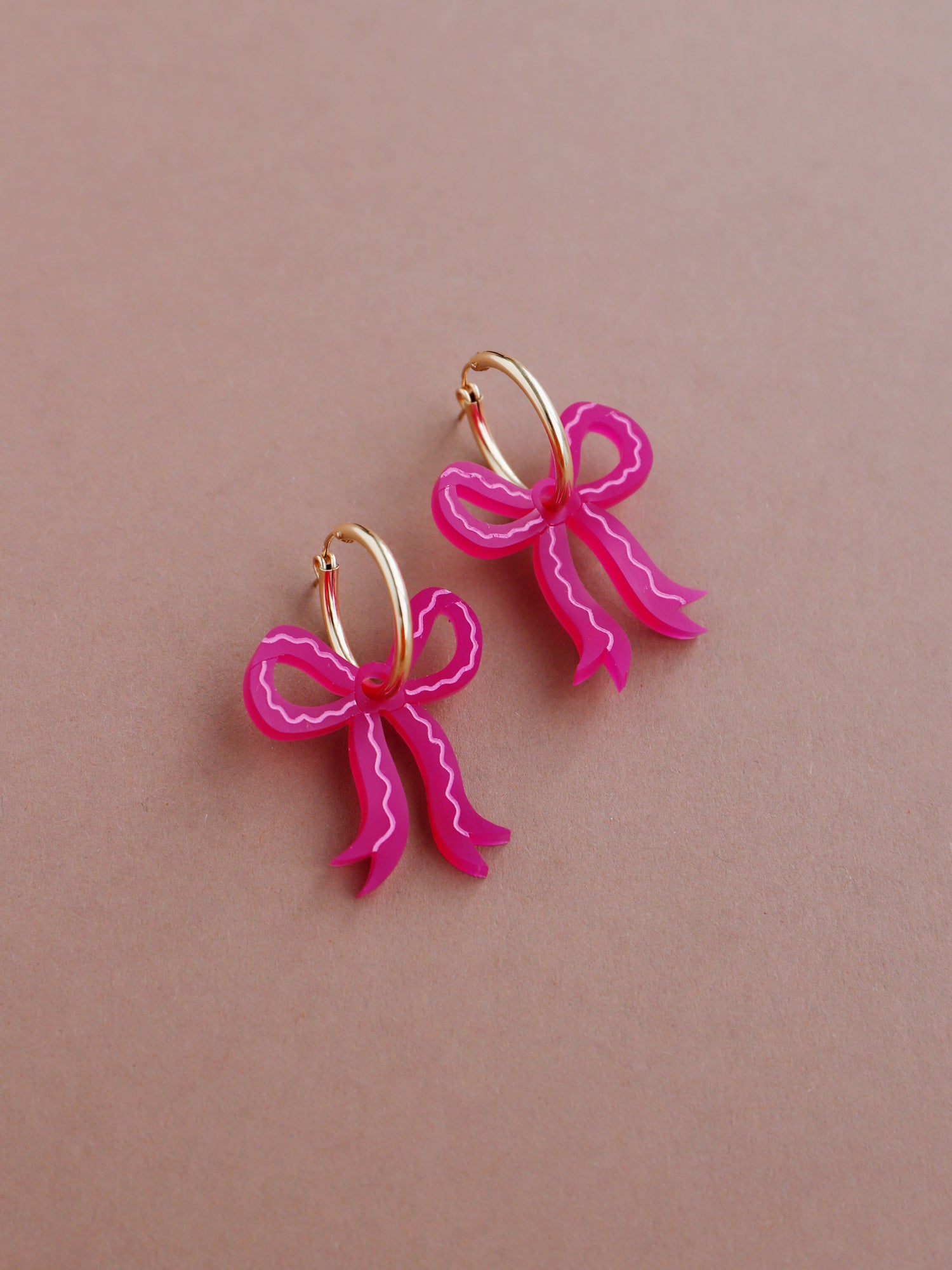 Romantic mini bow earrings in a recycled pink made from velvety marbled acrylic with hand-inked details. Surprisingly lightweight so can be worn for extended periods of time. Each bow is hand-sculpted into a 3D form giving it a lovely realistic ribbon-like effect. This also adds a unique charm to each one. Handmade by Wolf & Moon in the UK. ⁠