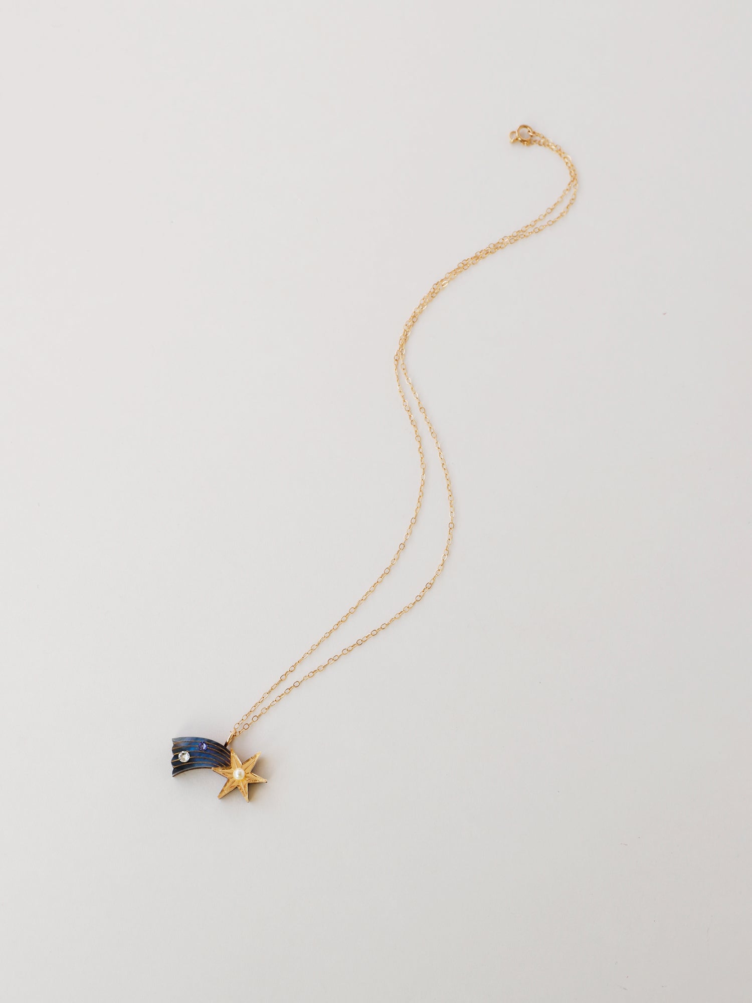 Shooting Star pendant necklace made with laser cut deep blue acrylic, Czech glass pearls and hand inked details. Wear with our 14k gold-filled chain. Handmade in the UK by Wolf & Moon.