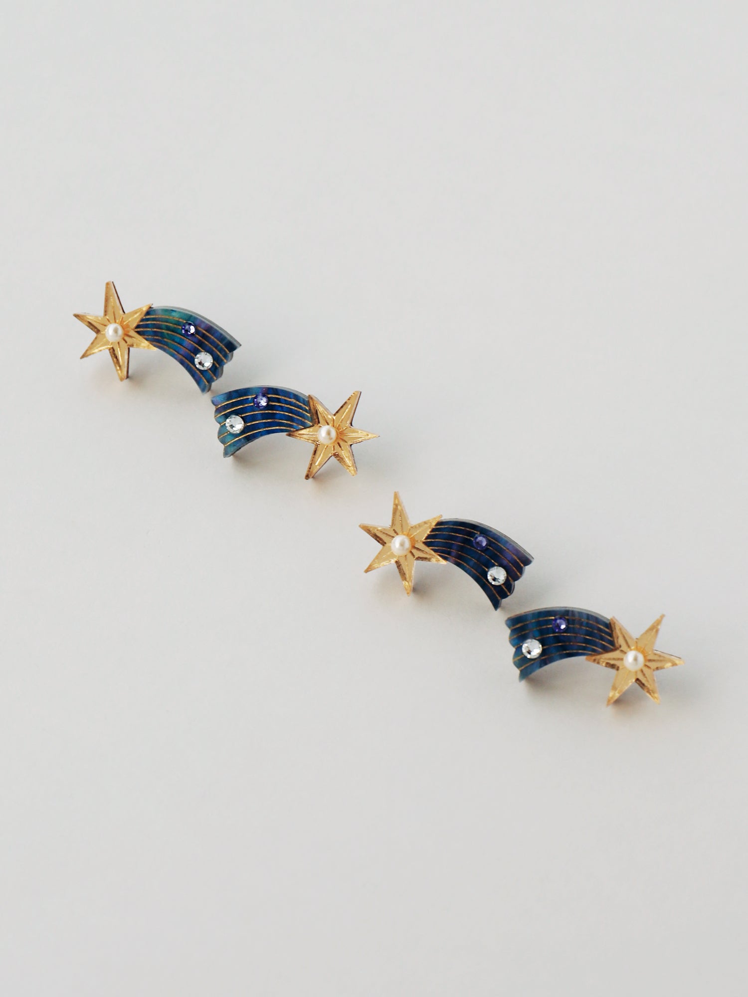 Shooting Star stud earrings made with laser cut deep blue acrylic, Czech glass pearls and hand inked details. Handmade in the UK by Wolf & Moon.