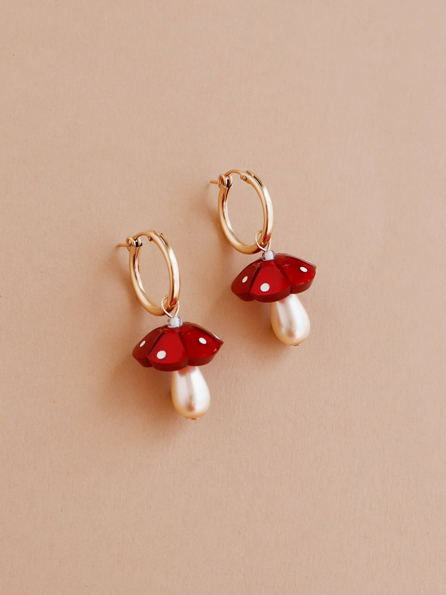 Red woodland mushroom charm hoops. Made from heat-formed acrylic with hand-inked details, and finished off with high quality Czech glass pearls and 14k gold-filled findings. Handmade in the UK by Wolf & Moon.
