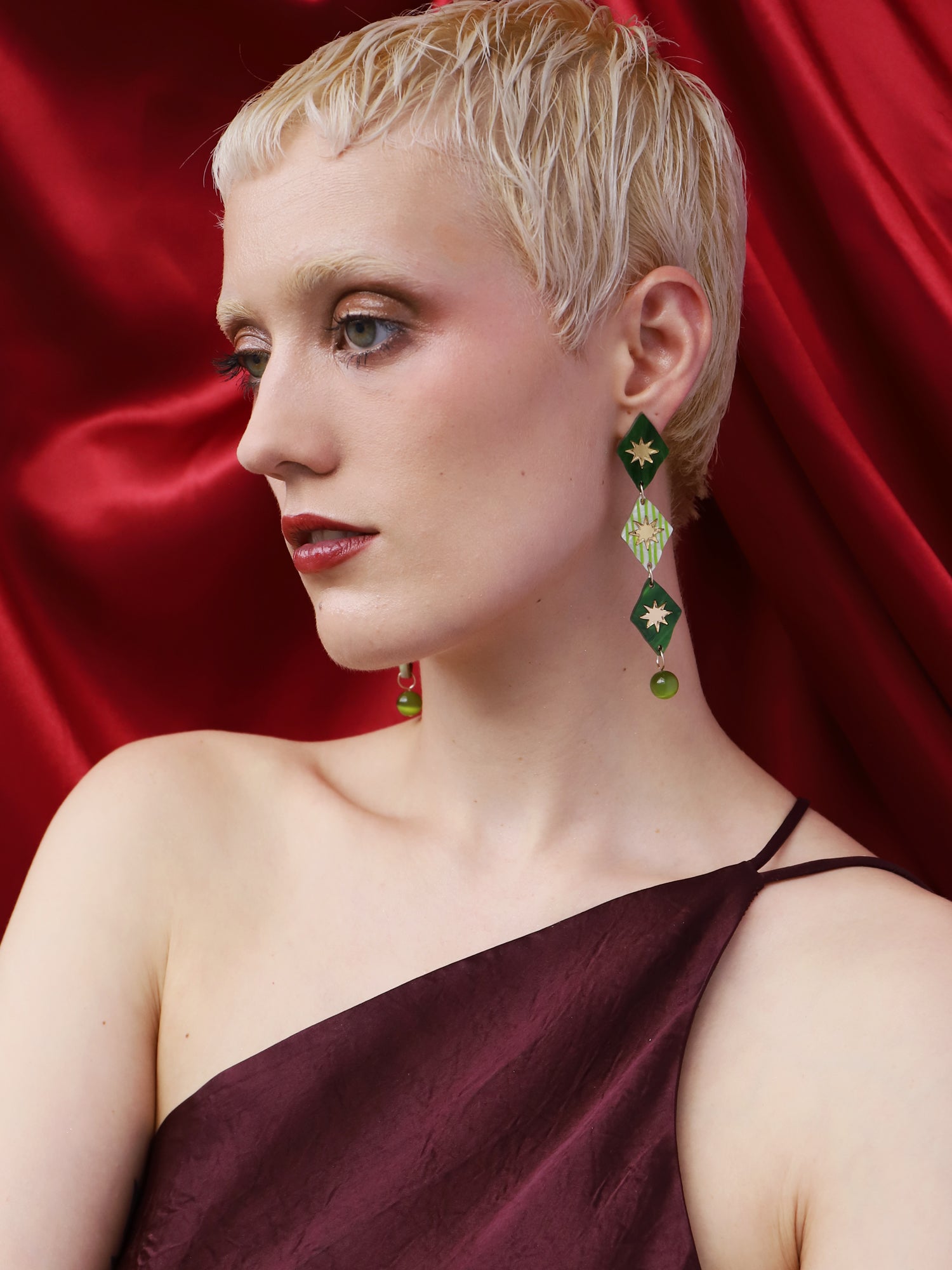 Harley Statement Earrings in Jade worn by a model with short blonde hair against a red backdrop.