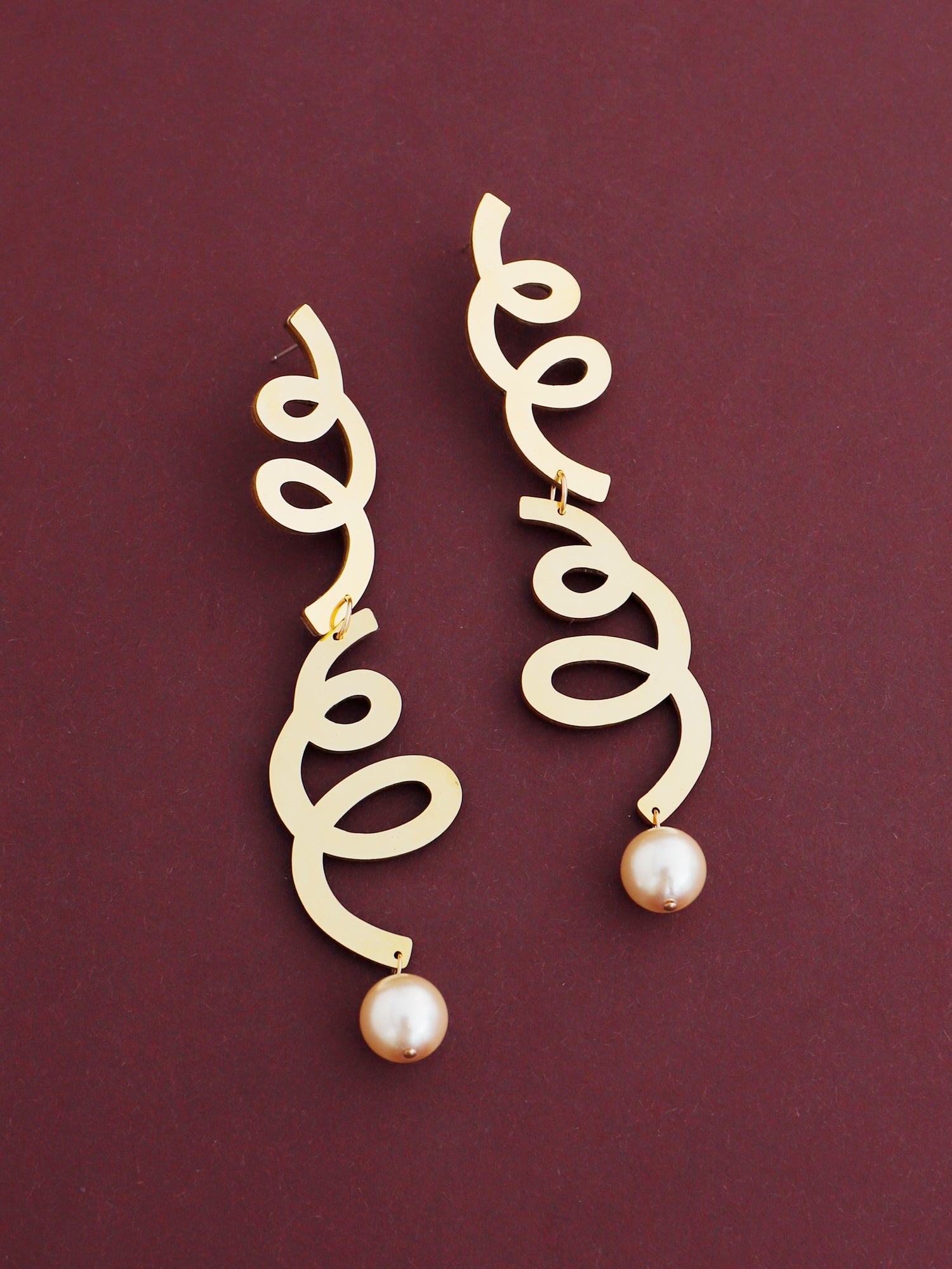 Lola Statement Earrings in Brass. Curly asymmetric statement earrings made in brass with our signature wood base, Czech glass baroque pearls, 14k gold-filled chain and sterling silver earring posts. Made in the UK by Wolf & Moon.