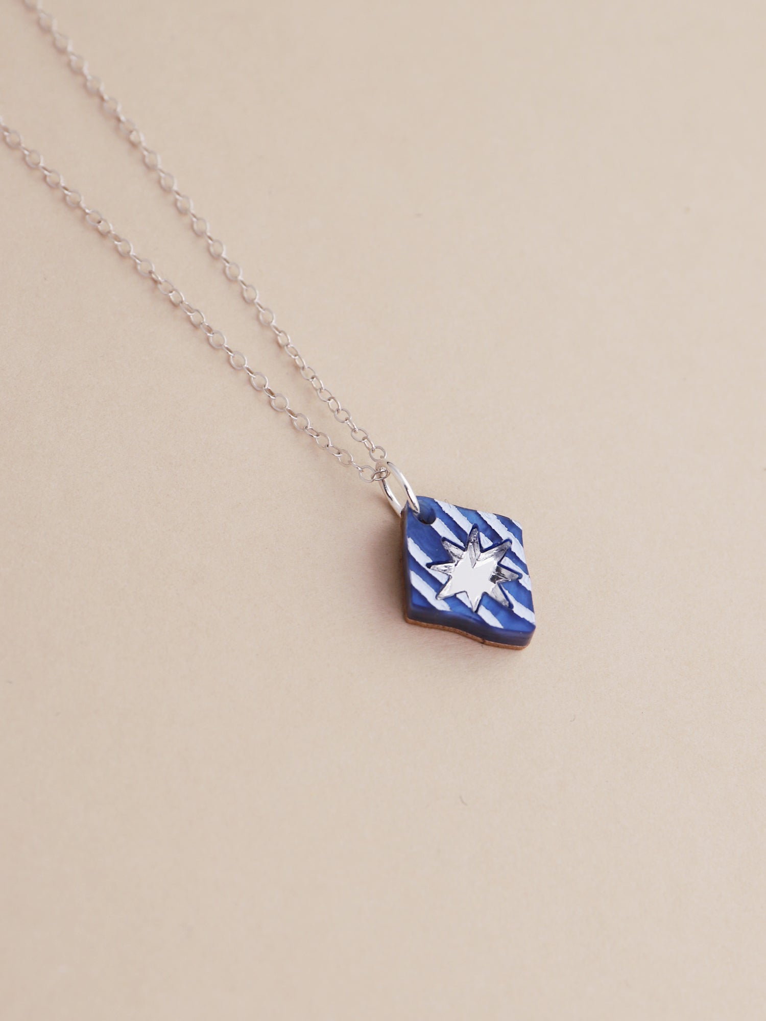Nova Necklace in Sapphire by Wolf & Moon, handmade in UK, featuring intricate hand-inked details and a silver chain.