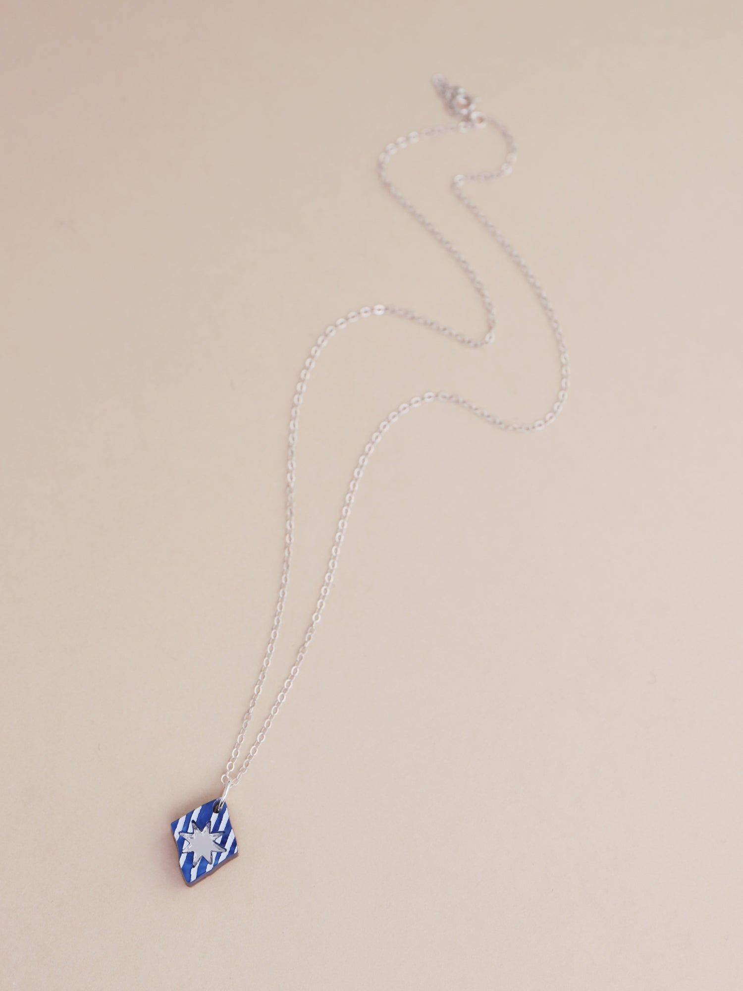 Nova Necklace in Sapphire, handmade in UK by Wolf & Moon, featuring intricate design and optional silver chain.