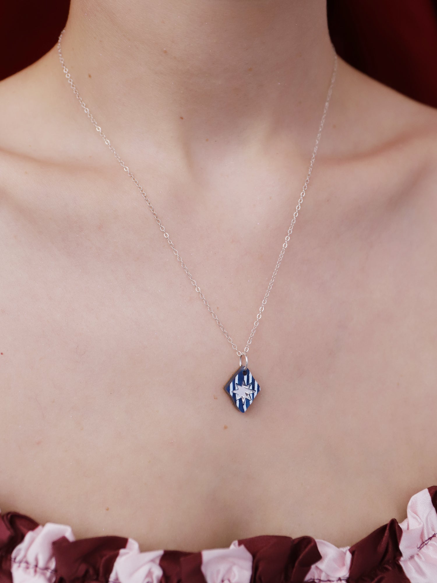 Model wearing Nova Necklace in Sapphire on a silver chain, showcasing intricate designs. Handmade in UK by Wolf & Moon.