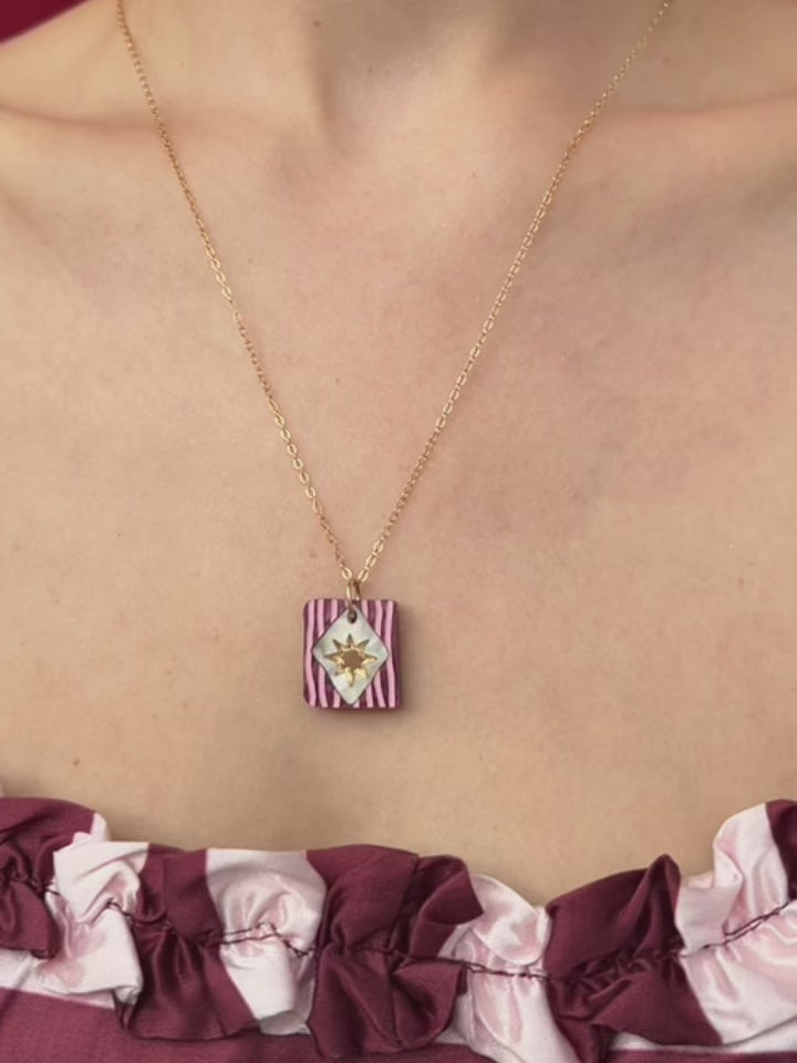 Stella Necklace in Cherry worn by a model, featuring a unique design with gold accents and a lightweight gold-filled chain.