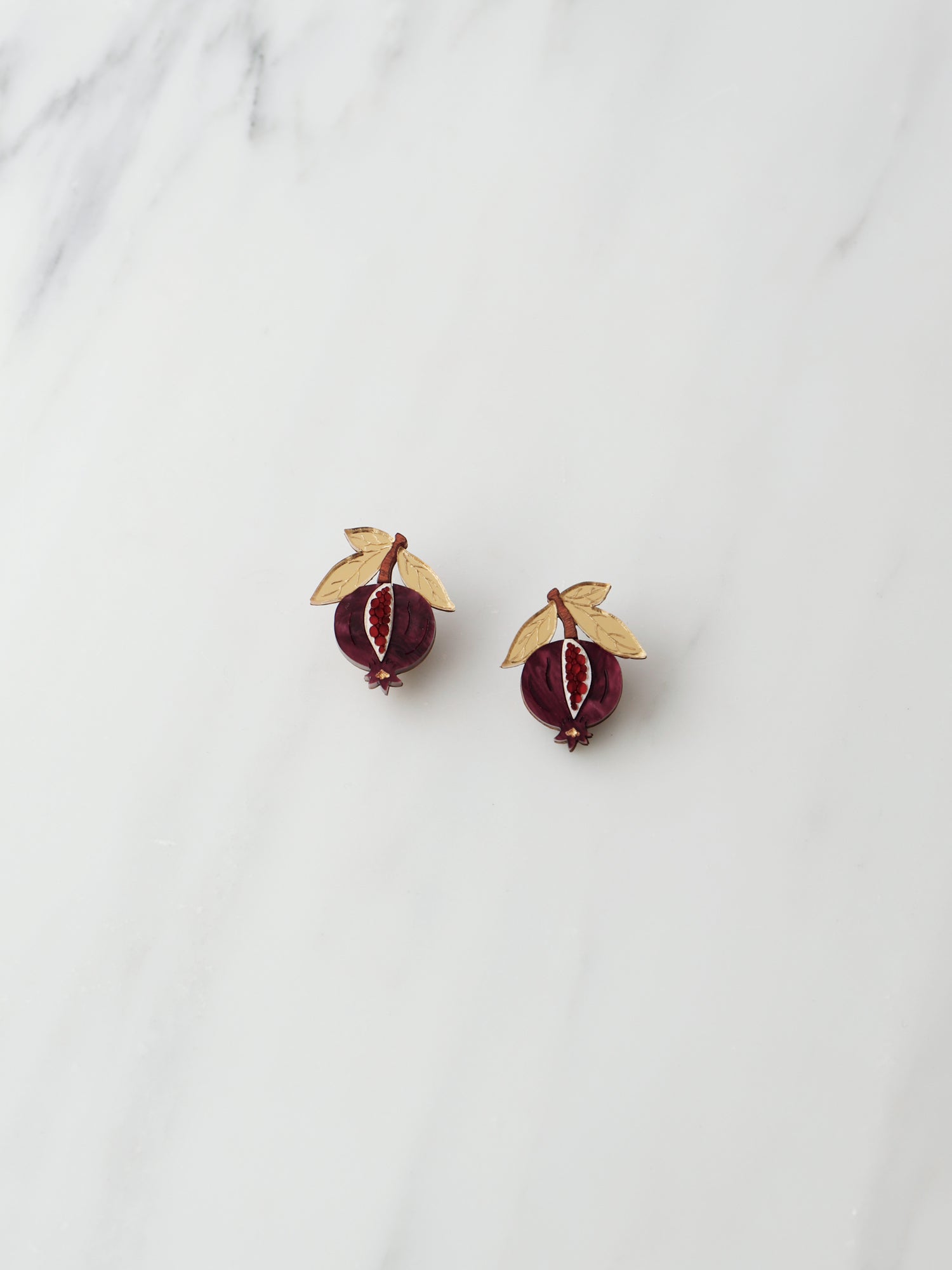 Pomegranate stud earrings made with wood, acrylic and hand-inked details. Handmade in the UK by Wolf & Moon.