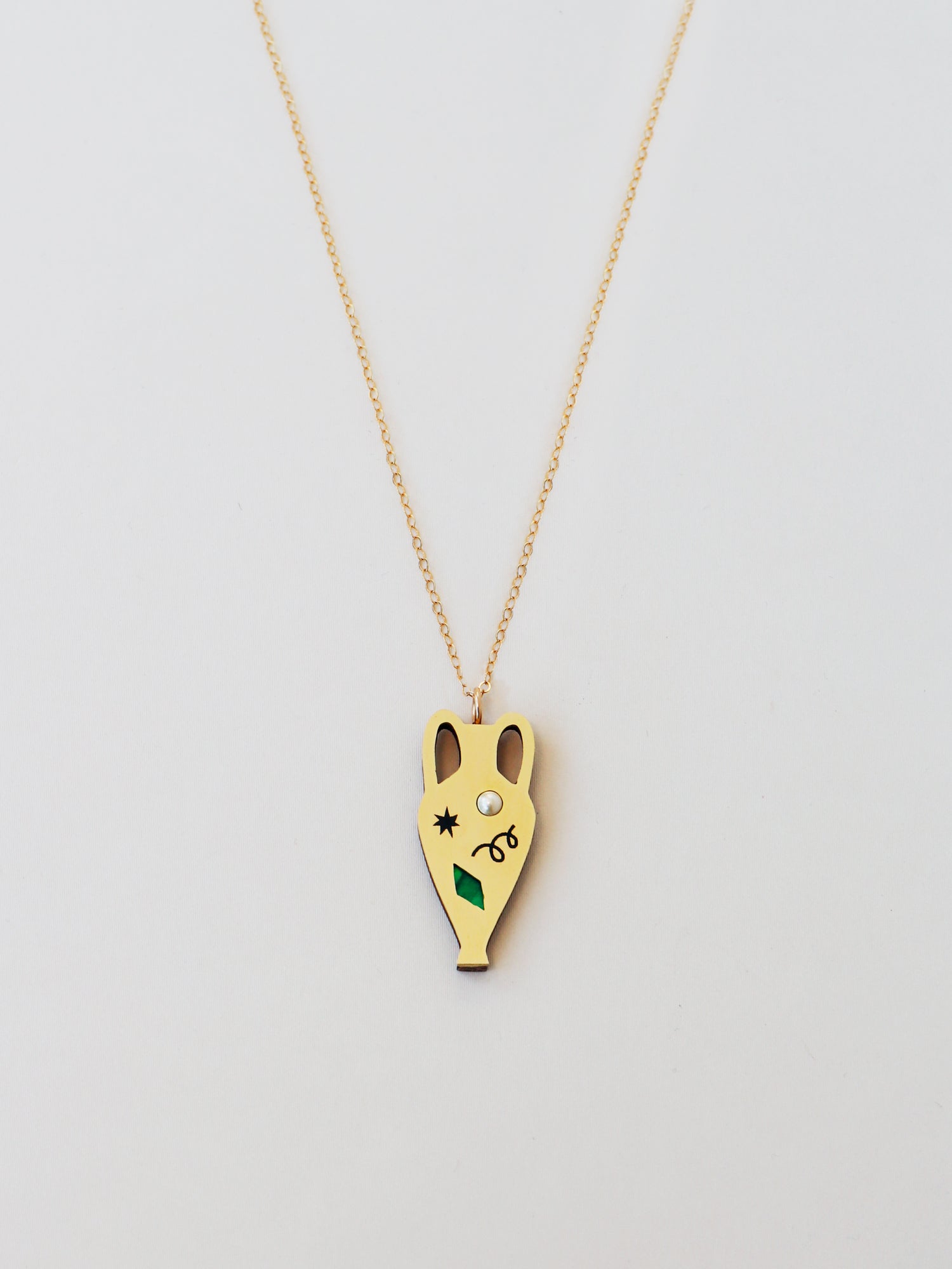 Brass vase shape pendant necklace. Glass pearls and abstract cut outs with inlaid shell and illustrative detailing. Handmade in the UK by Wolf & Moon.