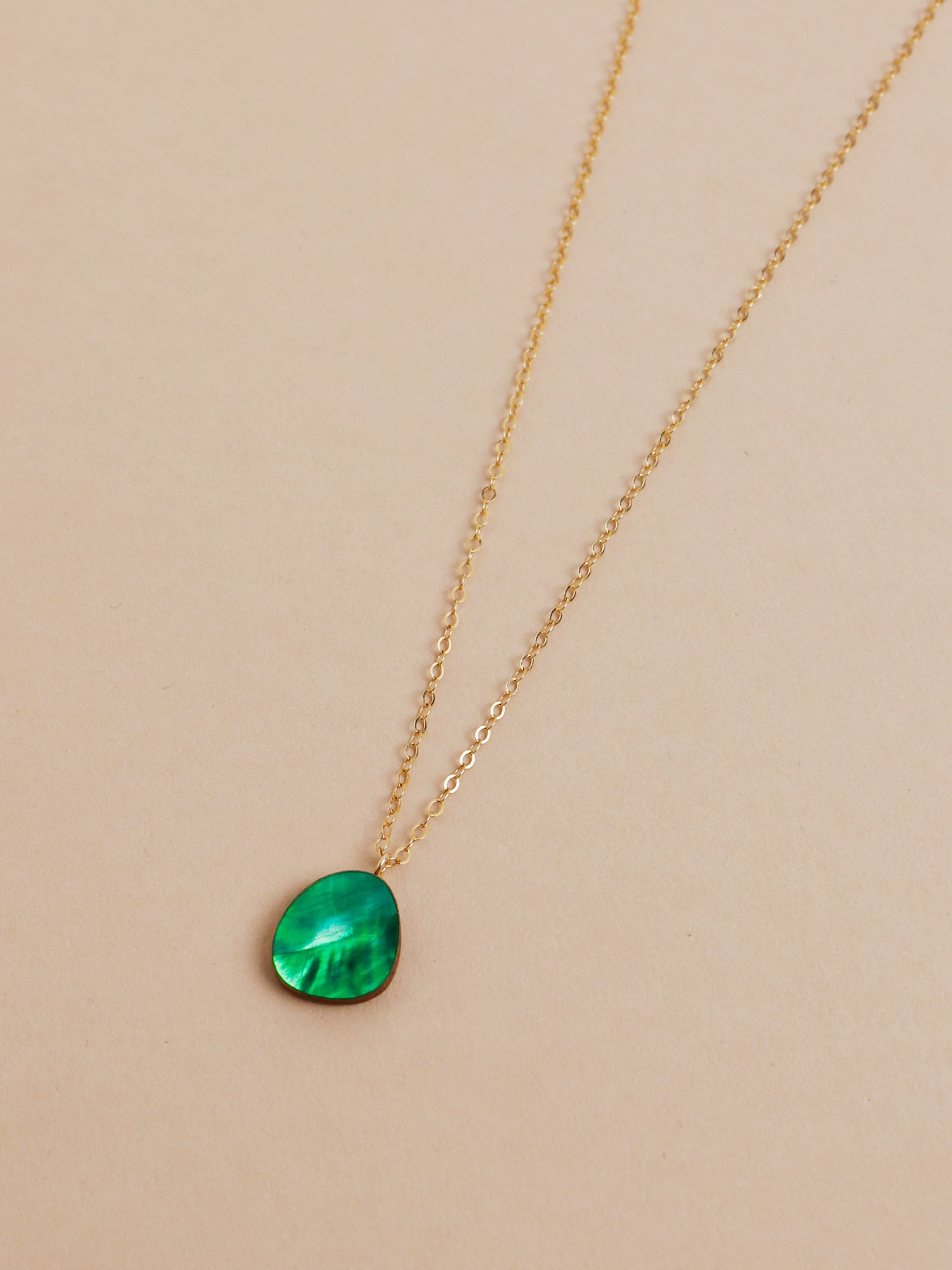 Beatrice Necklace in Emerald. Simple abstract pendant featuring emerald mother of pearl veneer and a 14k gold-filled chain. Handmade in the UK by Wolf & Moon.