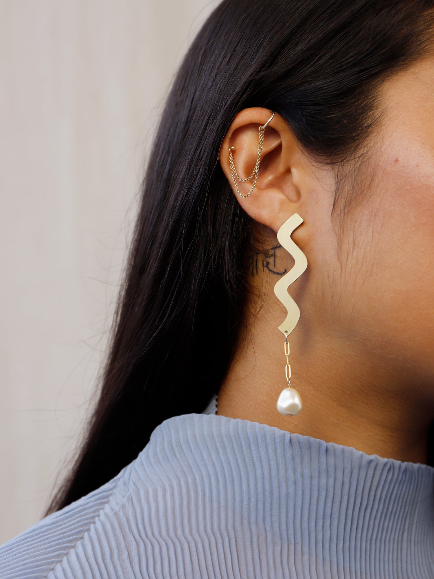 Martha Earrings in Brass. Wavy asymmetric statement earrings made in brass with our signature wood base, Czech glass baroque pearls, 14k gold-filled chain and sterling silver earring posts. Made in the UK by Wolf & Moon.