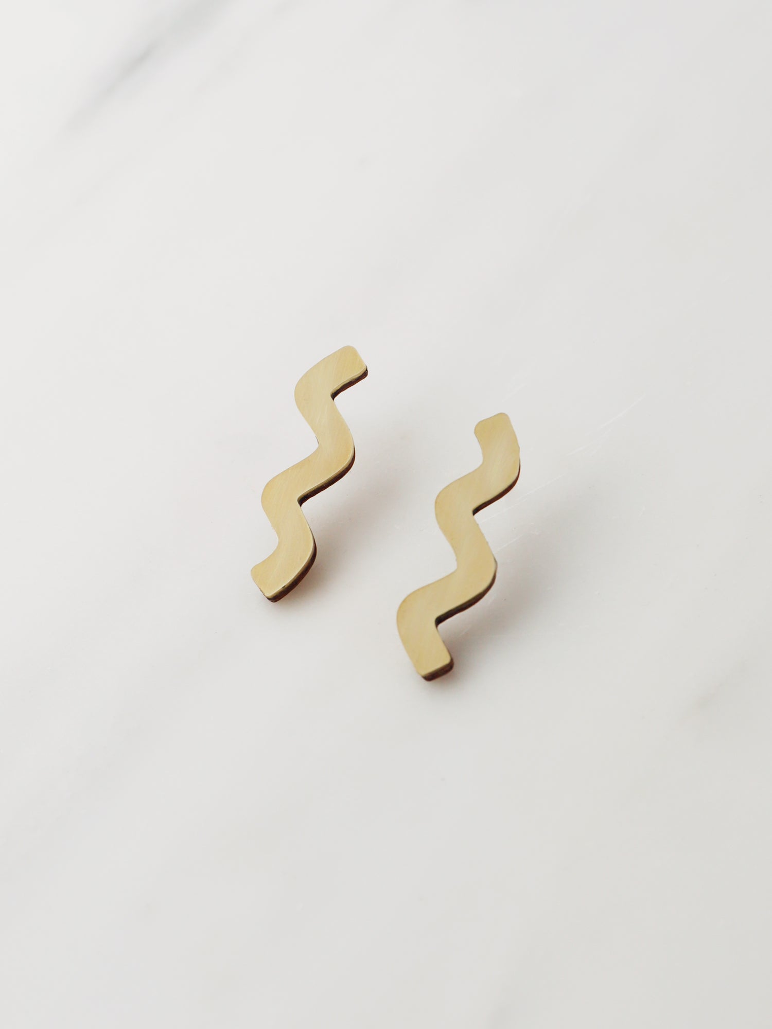 Playful wavy studs in brass with our signature wooden back and sterling silver earring posts. Handmade in the UK by Wolf & Moon.