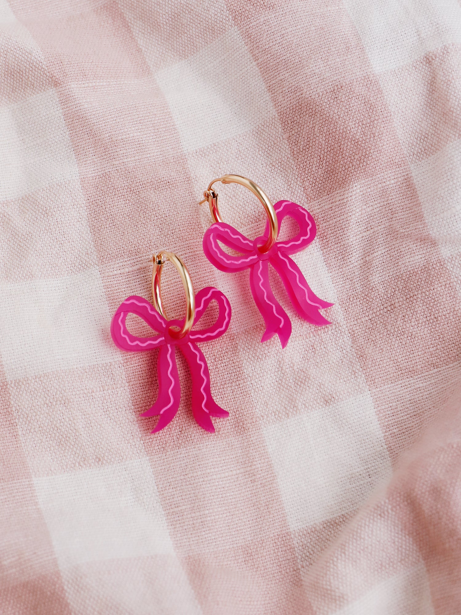 Romantic mini bow earrings in a recycled pink made from velvety marbled acrylic with hand-inked details. Surprisingly lightweight so can be worn for extended periods of time. Each bow is hand-sculpted into a 3D form giving it a lovely realistic ribbon-like effect. This also adds a unique charm to each one. Handmade by Wolf & Moon in the UK. ⁠