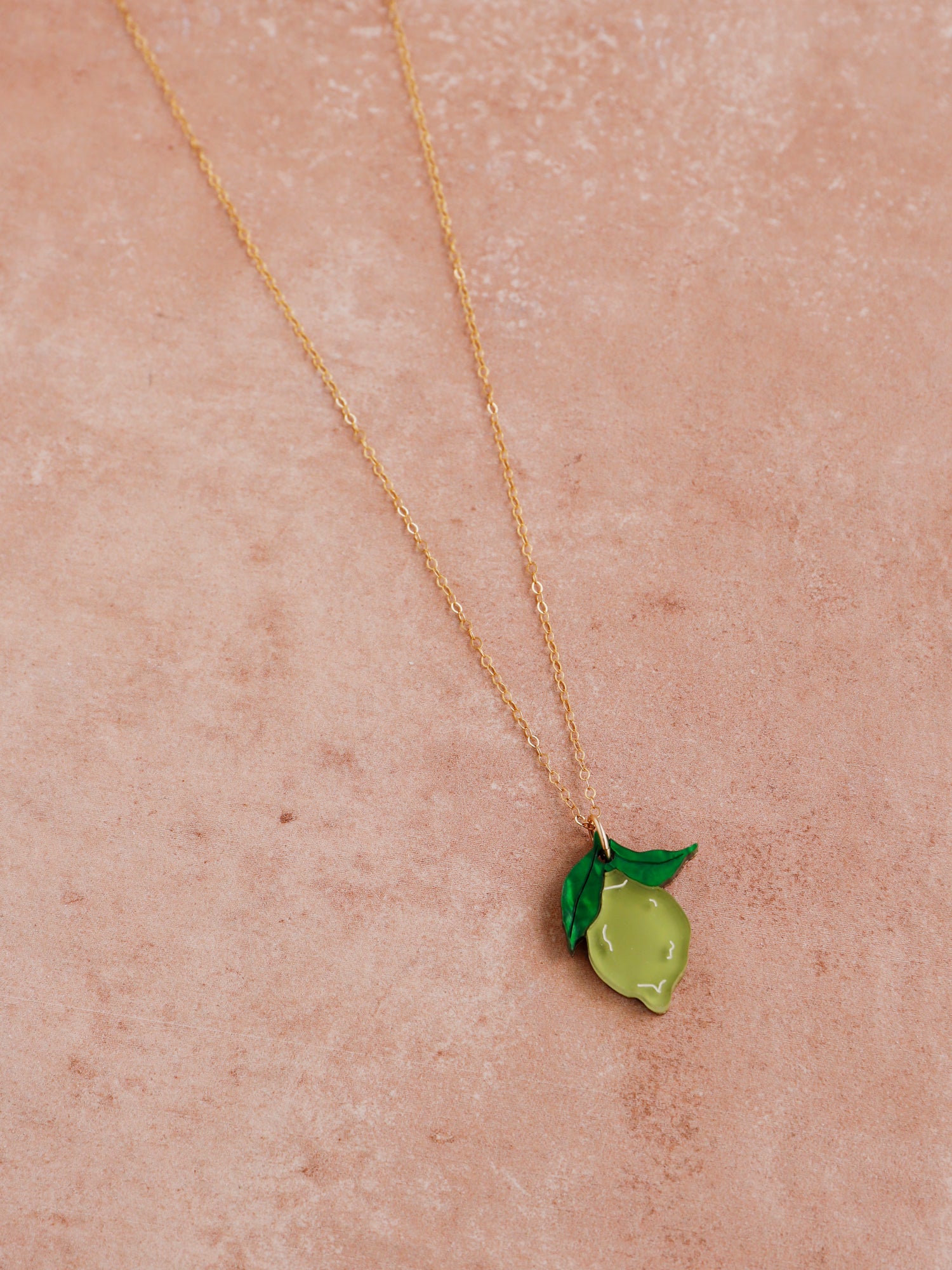 Lime pendant necklace with green leaf made with wood, 64% recycled acrylic and hand-inked details. Hung on a high quality 45cm gold-filled chain. Handmade in the UK by Wolf & Moon.