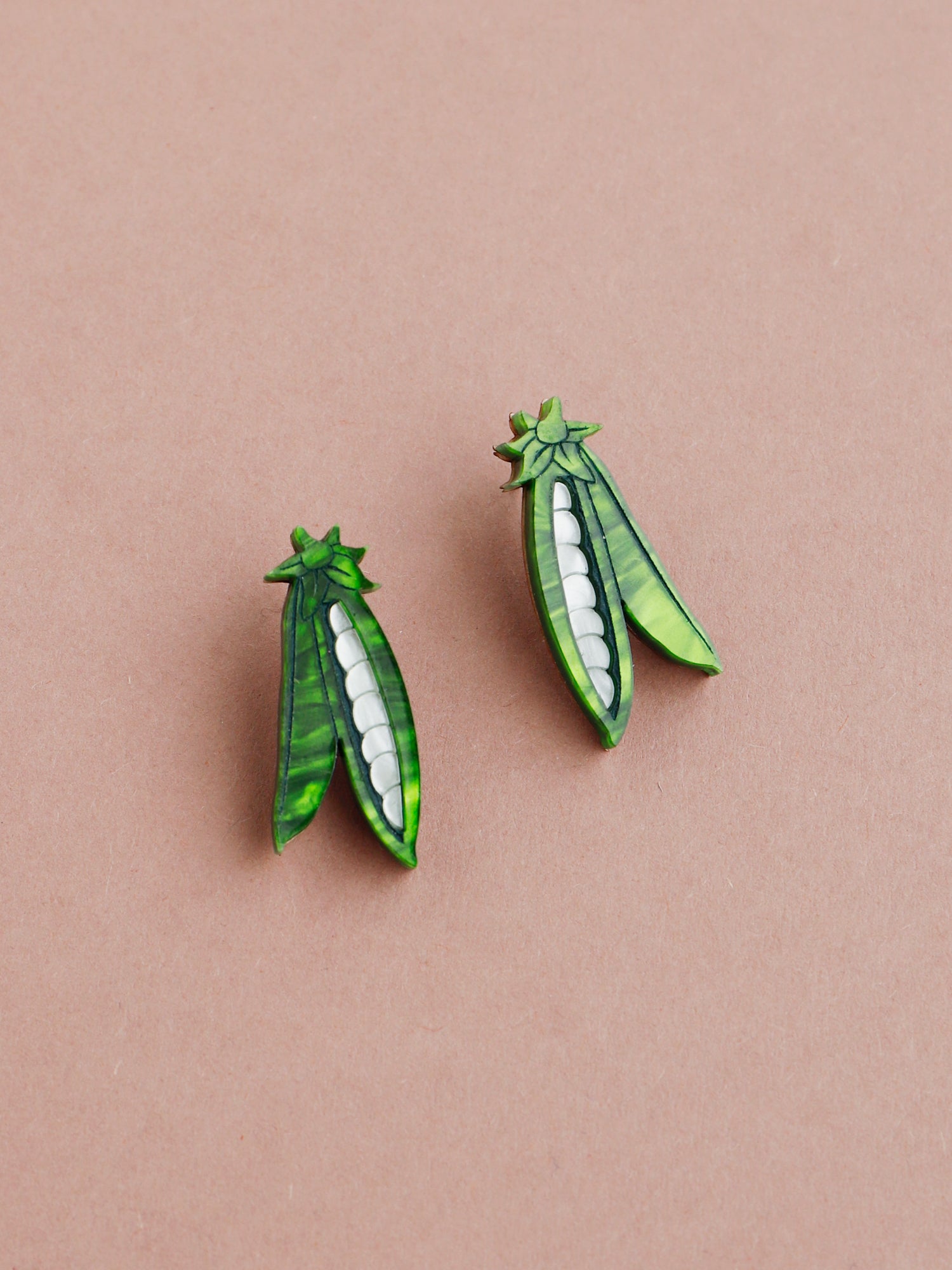 These playful peas in a pod stud earrings are made from marbled acrylic, wood with sterling silver posts. Handmade in London by Wolf & Moon.