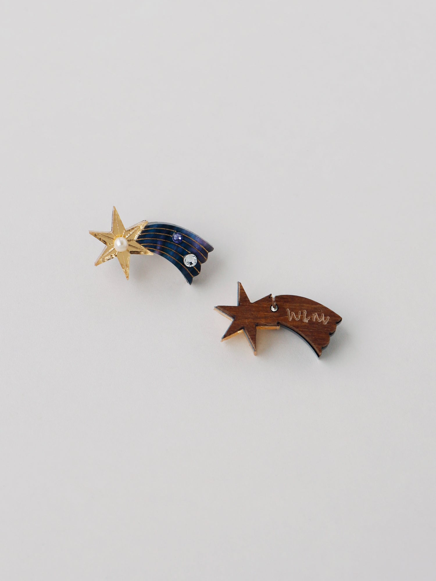Shooting Star stud earrings made with laser cut deep blue acrylic, Czech glass pearls and hand inked details. Handmade in the UK by Wolf & Moon.