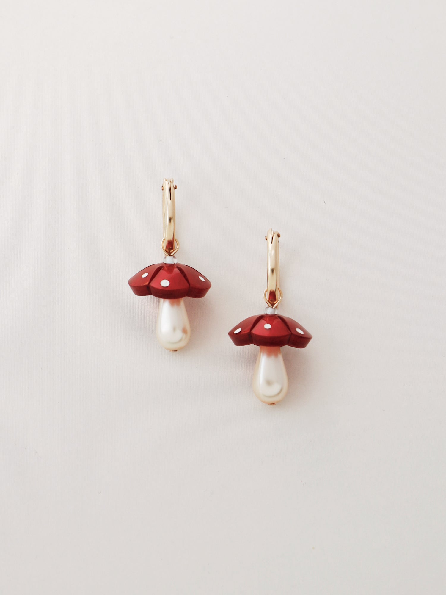 Red woodland mushroom charm hoops. Made from heat-formed acrylic with hand-inked details, and finished off with high quality Czech glass pearls and 14k gold-filled findings. Handmade in the UK by Wolf & Moon.
