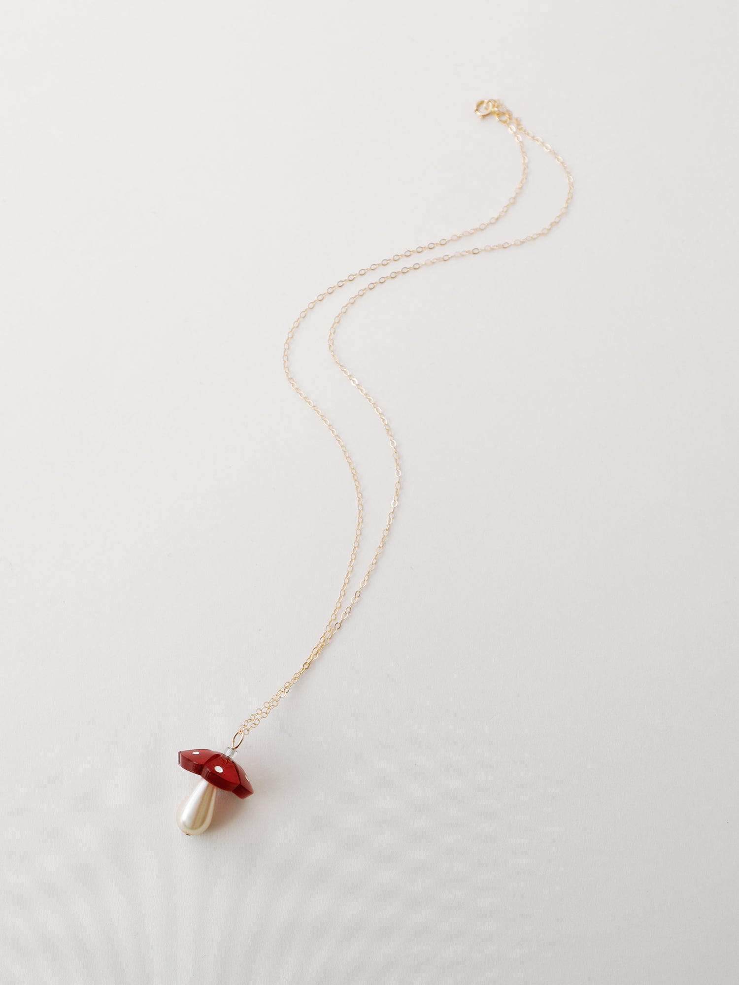 Red mushroom pendant necklace. Made from heat-formed acrylic with hand-inked details and finished off with a high quality Czech glass pearl. Pendant is hung on a high quality 50cm 14k gold-filled chain. Handmade in the UK by Wolf & Moon.