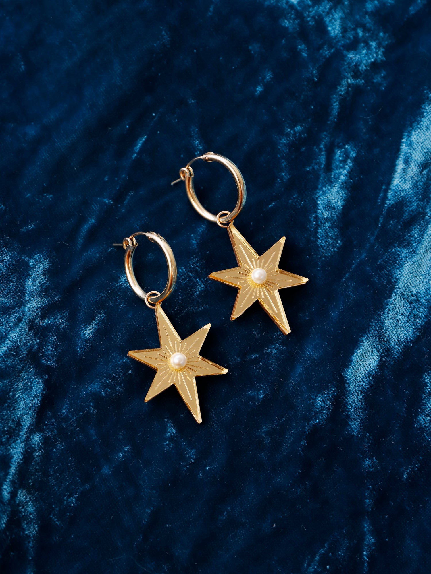 Statement star hoops made with gold mirrored acrylic, embellished with glass pearls and hand inked details. Handmade in London by Wolf & Moon.