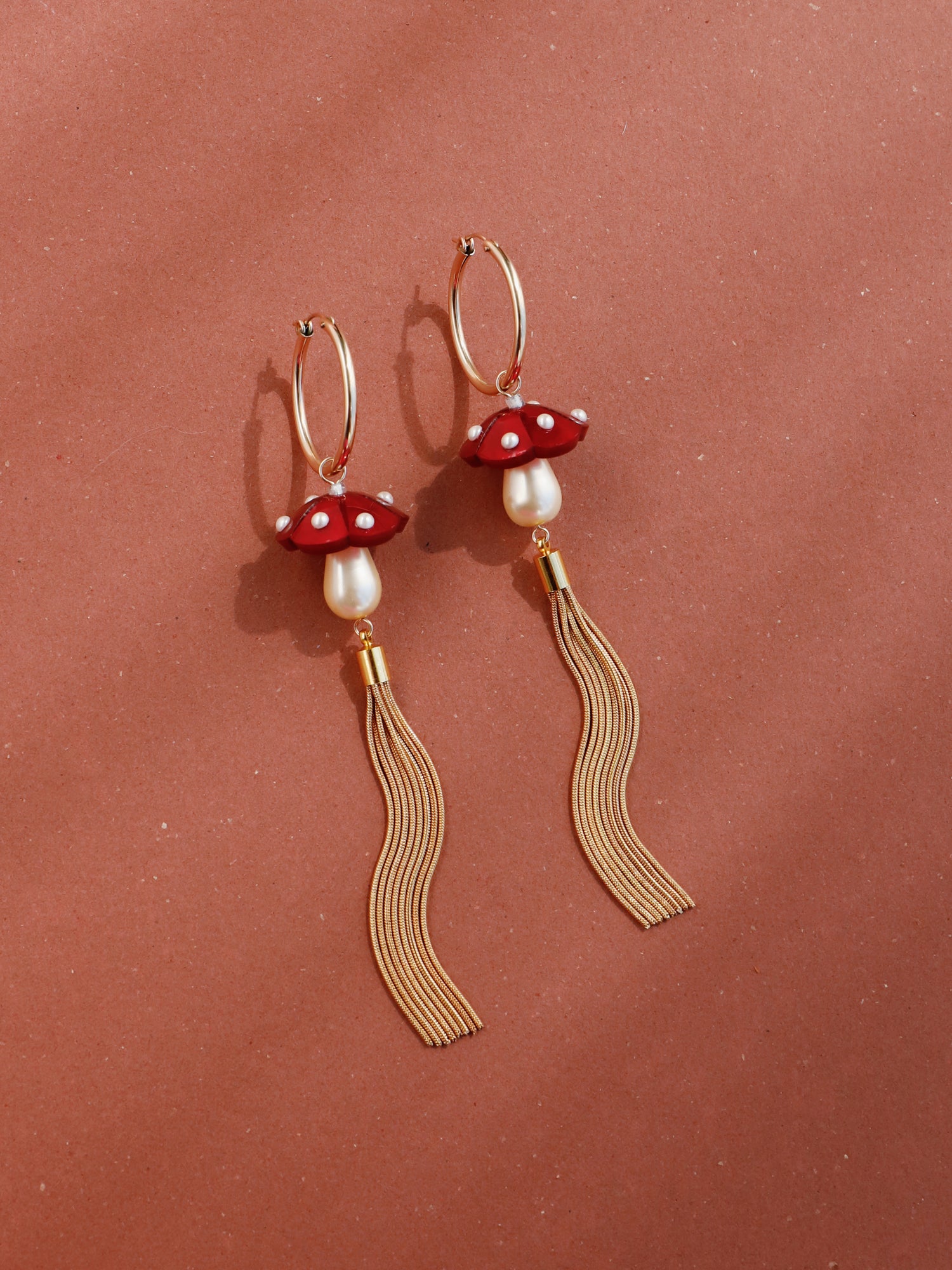 Marbled red acrylic statement mushroom hoops with gold plated snake chain tassels. Finished with high quality Czech glass pearls. Handmade by Wolf & Moon. 